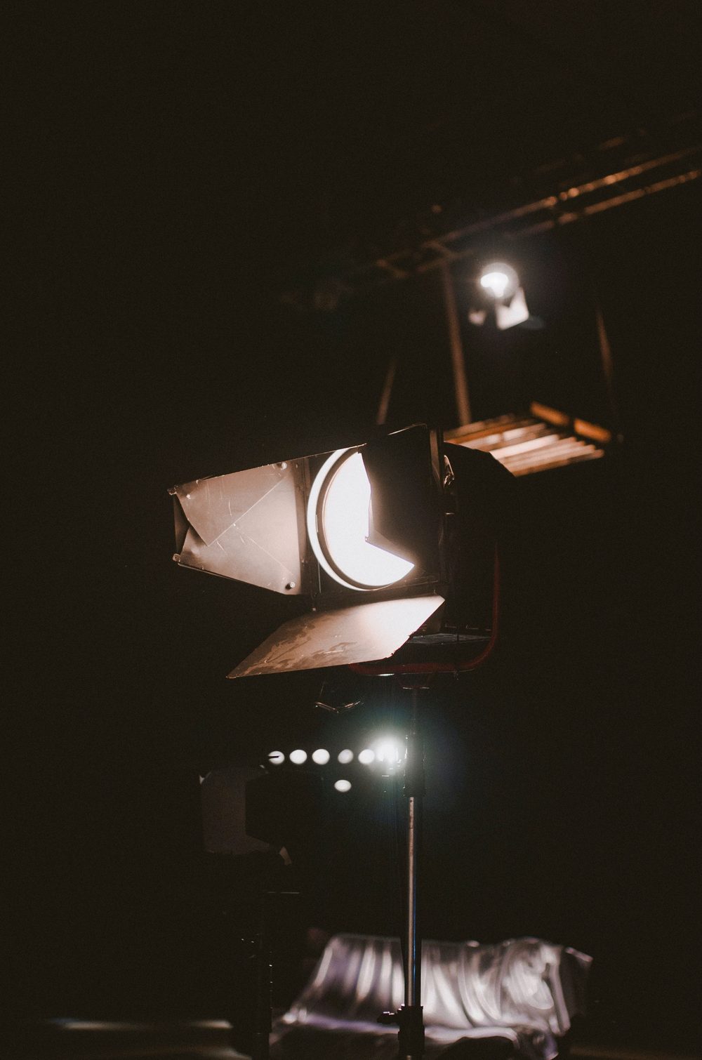 Fresnel con barndoors sobre un pie de luz en un set oscuro